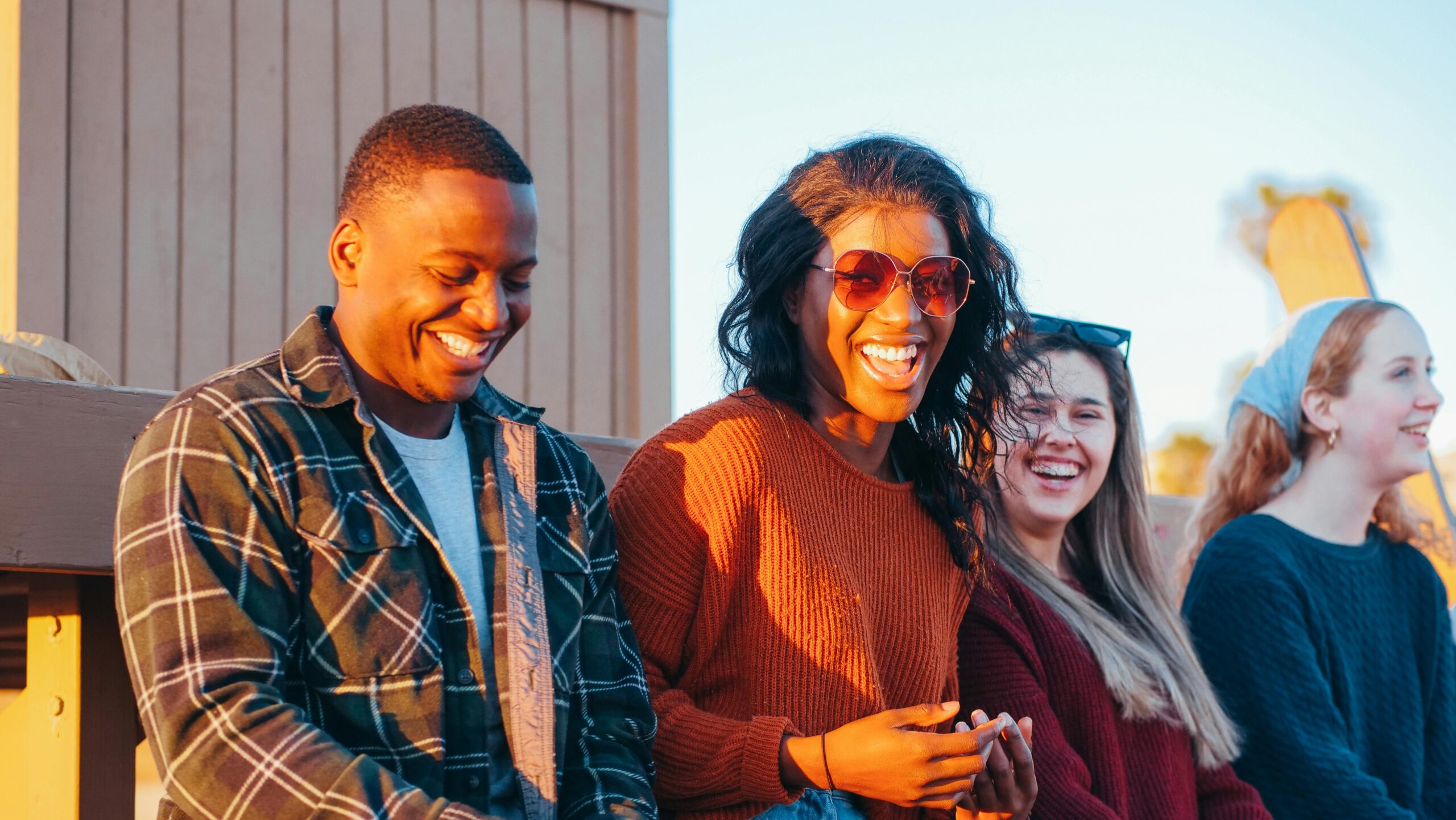 A group of diverse friends enjoy a fun moment at sunset, showcasing joy and friendship.